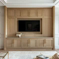 a large entertainment center with wooden cabinets and a flat screen tv mounted on the wall