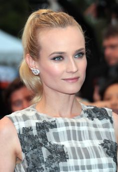 a woman with blonde hair and blue eyes is posing for the camera at an event