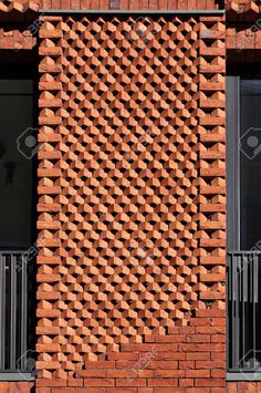 the side of a brick building with windows and balconies