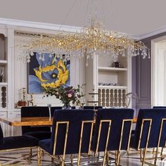 a dining room table with blue chairs and a chandelier