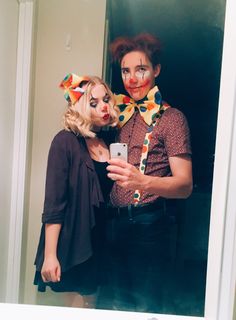 two people dressed up as clowns taking a selfie