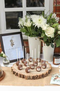 there is a cake on the table with white flowers in the vases and pictures