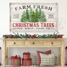 a christmas tree sign is on the wall above a table with presents and wrapped presents