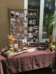 a table topped with pictures and pineapples on top of a purple table cloth