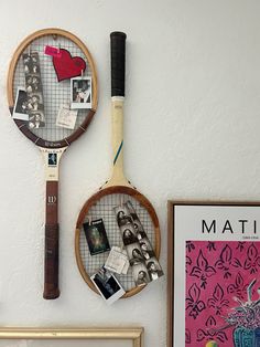 two tennis racquets hanging on the wall next to pictures and other items