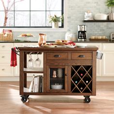 a kitchen island with wine bottles on it in the middle of a wooden flooring area