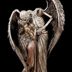 a bronze statue of an angel and a skeleton holding hands with their backs to each other