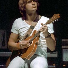 a man playing an acoustic guitar on stage