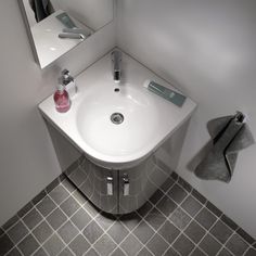 a white sink sitting under a bathroom mirror next to a towel dispenser