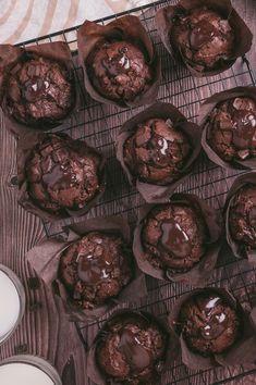 chocolate muffins cooling on a wire rack next to milk