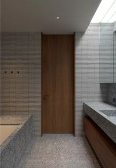 a bathroom with two sinks and a bathtub next to a wooden door in the wall