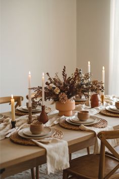 a dining table set with plates and place settings