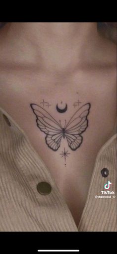 a woman's chest with a butterfly and moon tattoo on her left side breast