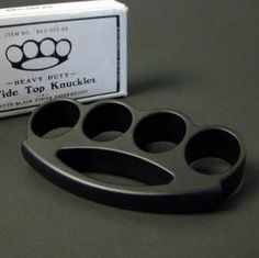 an empty cupcake pan next to a box of knucks on a table