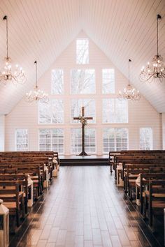 the inside of a church with pews and chandeliers