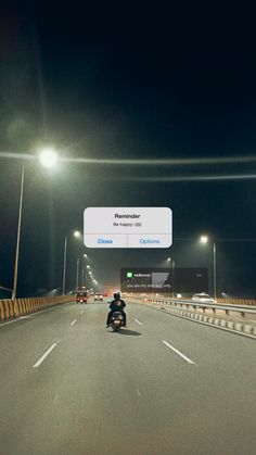 a man riding a motorcycle down a highway at night