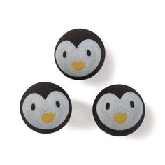 three black and white penguins with yellow eyes