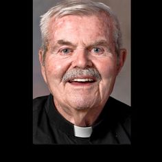 an older man wearing a priest's outfit with a cross on his chest and white hair