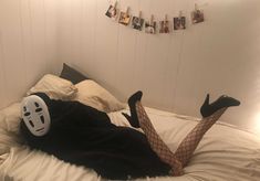 a person laying on top of a bed wearing a mask and fishnet tights