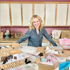 a woman standing in front of boxes full of items