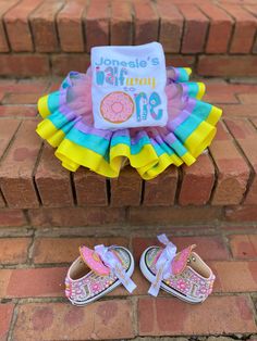 a pair of baby shoes sitting on top of a brick floor next to a sign