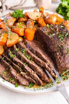 a white plate topped with meat and veggies