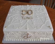 a 50th birthday cake with two wedding rings on it