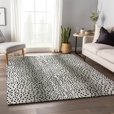 a living room with a white couch and black and white area rug on the floor