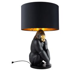 a gorilla lamp sitting on top of a table next to a black lampshade