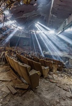 an abandoned auditorium with chairs and beams of light