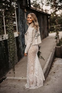 Bride in fitted lace wedding dress wearing cream leather jacket with personalised with her new last name on the back Leather Jacket Ideas, Wedding Leather Jacket, Barn Wedding Photos, Grey Bridesmaids, Jacket Ideas, Rustic Wedding Reception