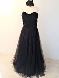 A stunning full length strapless Black Dress with matching Black Lace Choker. The dress has an elegant Sweetheart neckline with ruffled trimming. The bodice is elegantly ruched. The skirt of the dress is A-line and suits any figure. It is a full, but not puffy tulle skirt. The lace choker adds that extra UMPH to the dress. Its quite a thick choker, which gives it a unique appearance. Quite a statement maker! Size:  EU: 36/38 UK: 8/10 US: 4/6 Strapless Ruffled Evening Gown, Evening Strapless Ball Gown With Ruffles, Fitted Tulle Strapless Evening Dress, Strapless Evening Gown With Ruffles, Gala Strapless Tulle Dress With Ruched Bodice, Strapless Tulle Dress For Evening, Luxury Strapless Tulle Dress With Ruched Bodice For Gala, Formal Fitted Strapless Tulle Dress, Formal Strapless Fitted Tulle Dress