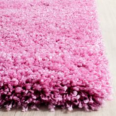 a pink area rug on a wooden floor