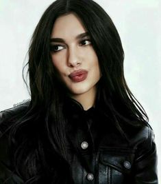 a woman with long black hair wearing a leather jacket