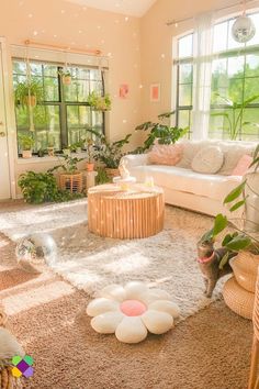 a living room filled with lots of furniture and plants on top of carpeted flooring