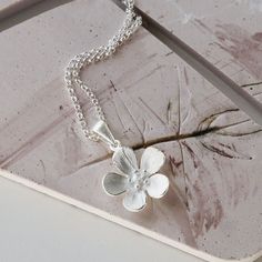 Walk on the wild side with Martha Jackson's wildflower pendant necklace.  Inspired by blooming English hedgerows in spring, this dainty necklace will bring joy to any outfit. Made from premium recycled sterling silver, Martha Jackson's floral necklace has the right amount of detail to pop, yet a shape so simple it'll go with anything.  The pendant comes on a fine belcher chain which sparkles subtly around the neck. Love to match? We've got wildflower stud earrings too. If you're looking for a gift that brings a smile, then this floral jewellery set is it! All of our sterling silver jewellery comes in a gift box with a blank gift card for you to write a short message on, making it a great letterbox gift. Silver Soldering, Silver Smithing, Bubble Earrings, Belcher Chain, Jewelry Drawing, Walk On The Wild Side, Jewelry Picture, Flower Pendant Necklace, Floral Necklace