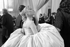 a black and white photo of a woman in a ball gown