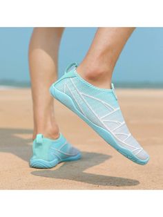 a person walking on the beach wearing aqua blue and white shoes with their feet in the sand