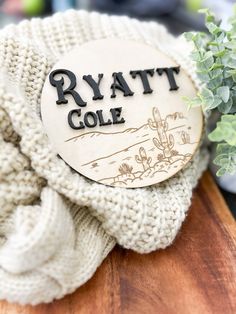 a white sweater sitting on top of a wooden table next to a potted plant