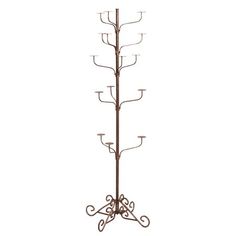 a coat rack with candles on it and an iron stand in the shape of a tree