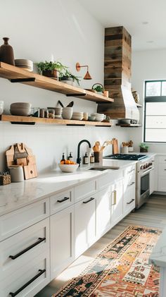 a kitchen with white cabinets and wooden shelves