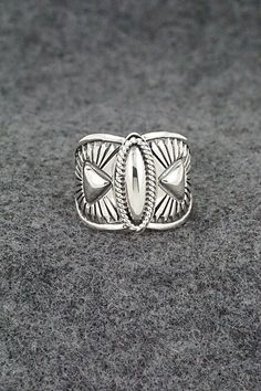 This finely crafted sterling silver ring was made by Navajo silversmith Derrick Gordon. The back is signed Derrick and stamped sterling. Size: 7.5 Length: 5/8" Free shipping on all orders! We ship with USPS and always include tracking. All orders ship within a day of payment. Returns are accepted up to 30 days after you receive your order. Just send us a message. Our shop offers cash back or store credit. The item must be returned in new condition. Artisan Sterling Silver Ring With Etched Details, Artisan Sterling Silver Etched Rings, Southwestern Style Silver Open Ring Jewelry, Southwestern Silver Open Ring Jewelry, Artisan Engraved Sterling Silver Ring 925, Artisan Sterling Silver Adjustable Engraved Ring, Artisan Sterling Silver Engraved Hallmarked Ring, Bohemian Silver Stamped Rings, Bohemian Stamped Silver Rings