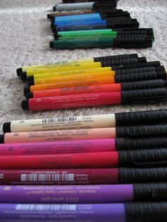 many different colored pens lined up on the floor