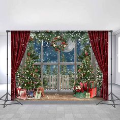 a christmas scene with presents and trees in front of a large window that has red curtains