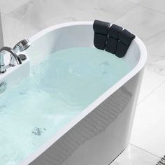 a white bath tub sitting on top of a tiled floor