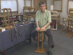 a man sitting on top of a wooden chair in a room filled with lots of items