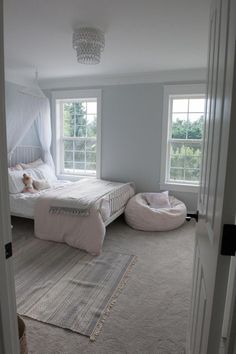 a bedroom with two white beds in it and a rug on the floor next to them