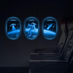 an airplane seat with three windows that have images of astronauts in space on the side