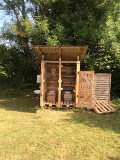 a wooden outhouse sitting on top of a lush green field