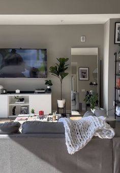 a living room filled with furniture and a flat screen tv mounted on the wall above it